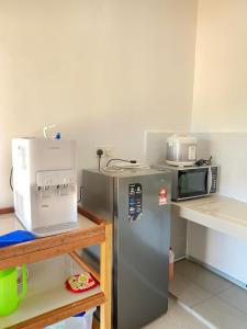 a kitchen with a refrigerator and a microwave at Makok Seaview roomstay in Kampung Penarik