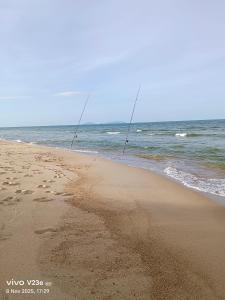 a couple of rods in the sand on a beach at Makok Seaview roomstay in Kampung Penarik