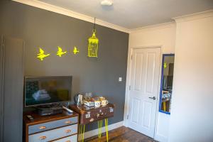 a room with a tv and a table and a bird cage at No4 Cromer in Cromer +31 photos