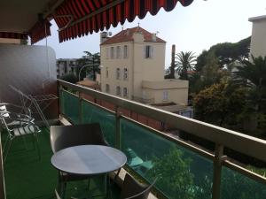 a balcony with a table and chairs and a building at Appartement le Saint James in Nice