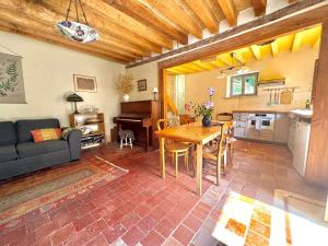 a living room with a table and a kitchen at Sweet Pea Cottage in Donzy +11 photos