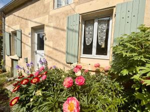a house with flowers in front of a window at Sweet Pea Cottage in Donzy