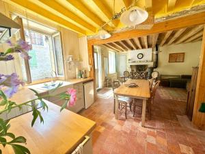 a kitchen and living room with a table and a kitchen and a dining room at Sweet Pea Cottage in Donzy