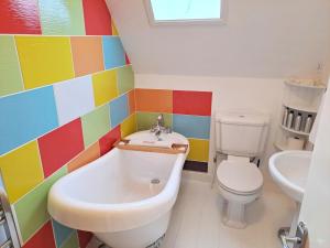 a colorful bathroom with a tub and a toilet at No4 Cromer in Cromer