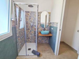 a bathroom with a shower with a sink and a mirror at Villetta Borgo Bianco 1 con piscina in condivisione in Budoni