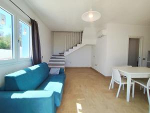 a living room with a blue couch and a table at Villetta Borgo Bianco 1 con piscina in condivisione in Budoni