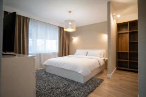 a bedroom with a white bed and a television at FF Residence in Deva