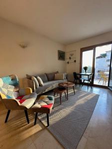 a living room with a couch and chairs and a table at Andromeda Sunset Suite & Spa in Tel Aviv