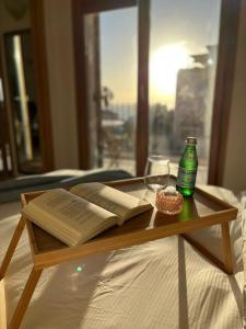 a wooden table with an open book and a bottle at Andromeda Sunset Suite & Spa in Tel Aviv