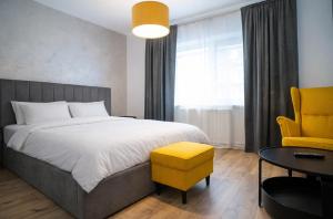 a bedroom with a large bed and a yellow chair at FF Residence in Deva +5 photos