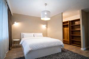 a bedroom with a large white bed and a table at FF Residence in Deva