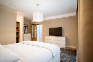 a bedroom with a bed and a flat screen tv at FF Residence in Deva