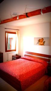 a bedroom with a red bed with a red comforter at Venice Resorts in Venice