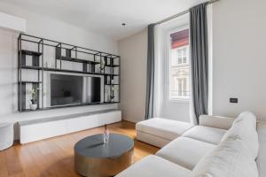 a living room with a white couch and a tv at Luxury Calzolerie in Bologna