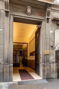 an entrance to a building with a clock on top at Luxury Calzolerie in Bologna