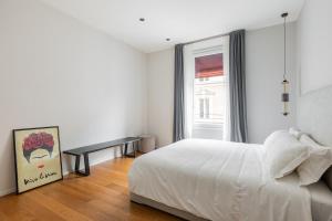 a white bedroom with a bed and a window at Luxury Calzolerie in Bologna