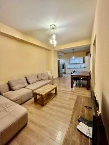 a living room with a couch and a table at Central Cozy 2-Bedroom in Tbilisi City +23 photos