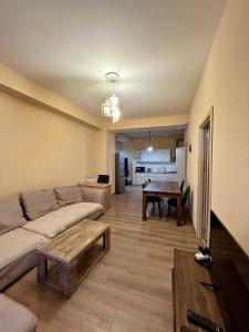 a living room with a couch and a table at Central Cozy 2-Bedroom in Tbilisi City