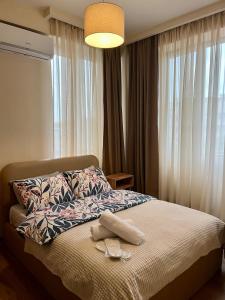 a bedroom with a bed with a pair of shoes on it at Central Cozy 2-Bedroom in Tbilisi City