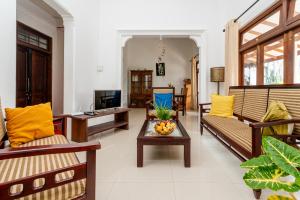a living room with couches and a table with a bowl of fruit at Lohas Beach Villa in Kalutara