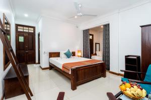 a bedroom with a bed and a chair in it at Lohas Beach Villa in Kalutara +19 photos