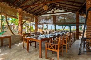 a long wooden table and chairs in a restaurant at Lohas Beach Villa in Kalutara