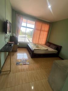a bedroom with a bed and a large window at ใบไม้ in Ko Si Chang