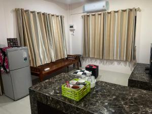 a living room with a counter with a refrigerator and a table at ใบไม้ in Ko Si Chang