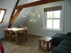 a living room with a table and a couch at Sint Nicolaashoeve in Nieuwveen