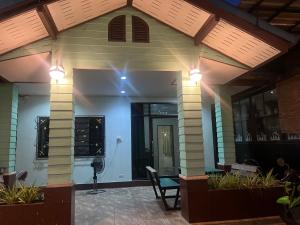a house with a porch with a green chair and lights at ใบไม้ in Ko Si Chang