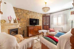 a living room with a fireplace and a tv at Es Pujols in Campanet