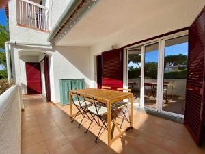 a patio with a wooden table and chairs on a house at Casa Manacá Vilamoura in Quarteira