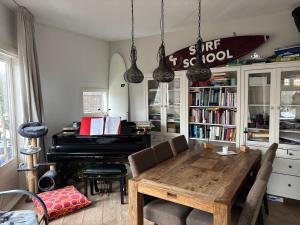 a dining room with a table and a piano at Nice apartment next to the beach in Scheveningen