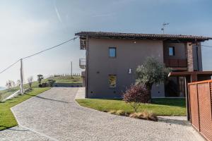 a house with a dog laying next to a driveway at LVguesthouse in Priocca