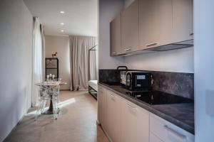 a kitchen with white cabinets and a table in a room at LVguesthouse in Priocca