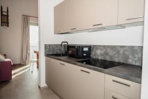 a kitchen with a sink and a microwave at LVguesthouse in Priocca +6 photos
