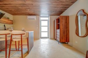 a kitchen with wooden ceilings and a counter with stools at Suite Moon & Spa in Amnéville