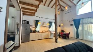 a kitchen and living room with a refrigerator and a table at Casa de Vacanta Nufarul Crisan in Tulcea