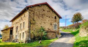 an old brick building on the side of a road at Gîte Chez Amélie in Le Monestier