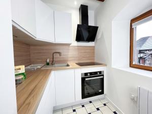 a kitchen with white cabinets and a sink at Chic Home - Turckheim in Turckheim