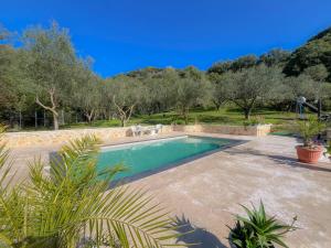 a swimming pool in a yard with trees in the background at Villa M&M met eigen zwembad in Kalamaki