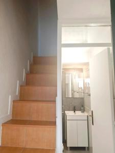 a bathroom with a staircase with a sink and a mirror at Casa do Adro in Torre de Moncorvo +1 photo