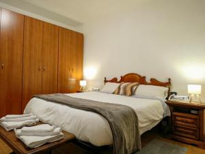 a bedroom with a large bed and a wooden cabinet at La Corte Nelle Vigne in Lavagno