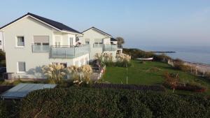 a house on a hill with the ocean in the background at Strandhaus-Seeschwalbe in Fehmarnsund