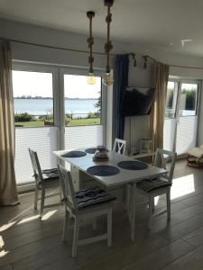 a table and chairs in a room with a view of the ocean at Strandhaus-Seeschwalbe in Fehmarnsund +32 photos