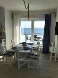 a dining room with a table and chairs with a view of the ocean at Strandhaus-Seeschwalbe in Fehmarnsund