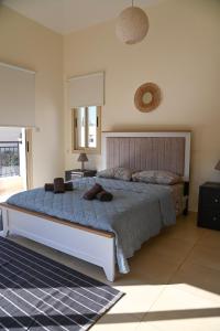 a bedroom with a large bed with two towels on it at Sorelia Latchi Villas 2 - Merope Irena in Polis Chrysochous +46 photos