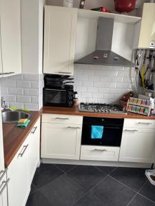 a kitchen with white cabinets and a stove top oven at Nice apartment next to the beach in Scheveningen
