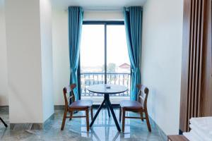 a table and chairs in a room with a balcony at 合意酒店 in Việt Yên