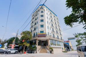 a tall white building with stairs in front of it at 合意酒店 in Việt Yên